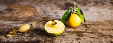 Ahşap bir masanın üzerine yayılmış Bergamot parfümü.