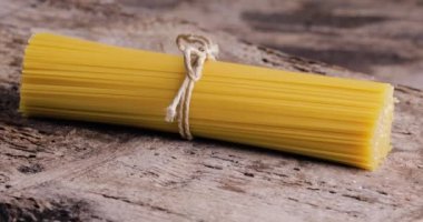 Tahta masada sarı, uzun bir spagetti. Çiğ spagetti..
