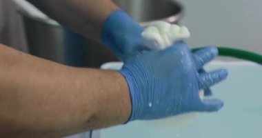 Süt ürünlerinde mozzarella peyniri yapan adamın yakın çekim görüntüleri.
