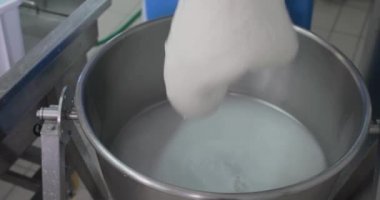 Süt ürünlerinde mozzarella peyniri yapan adamın yakın çekim görüntüleri.