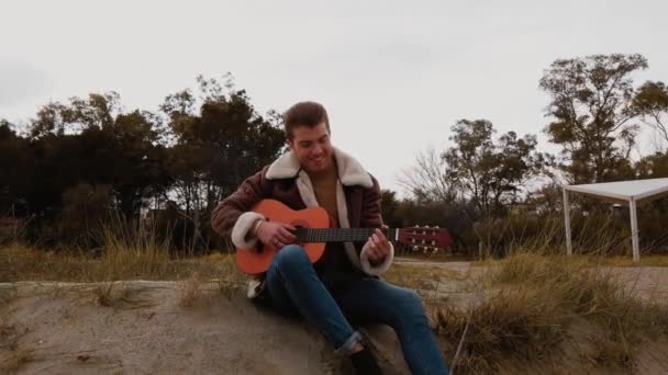 Młody Człowiek Siedzi Plaży Gra Gitarze — Wideo stockowe