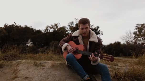 Jongeman Zittend Het Strand Gitaar Spelend — Stockvideo