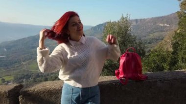 Güzel kız bir dağ gözlem güvertesinden manzaranın tadını çıkarıyor..