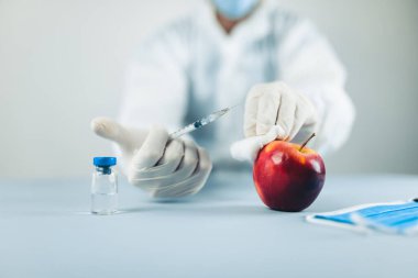 Genç erkek doktor, elmanın üstünde penis yapmayı öğreniyor.