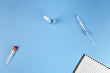 Mavi zemin üzerinde aşı olan şırınganın üst görünümü 