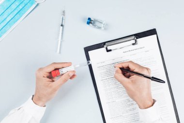 Erkek doktorların kesilmiş kısımları ellerinde tıbbi malzemelerle masada.