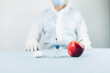 Genç erkek doktor, elmanın üstünde penis yapmayı öğreniyor.