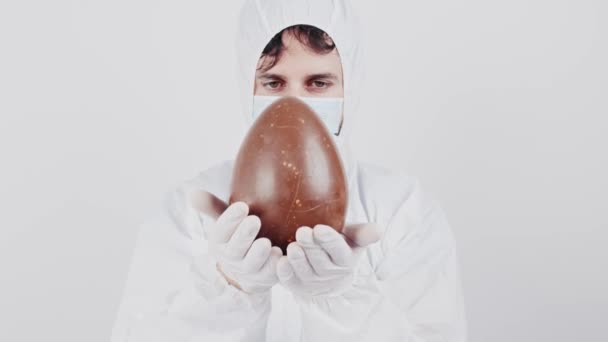 男性医師は離れてチョコレートイースターエッグ上の白い背景 — ストック動画