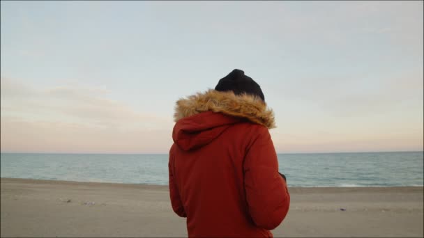 Jongeman Winterkleding Met Drone Het Strand Bij Zonsopgang — Stockvideo
