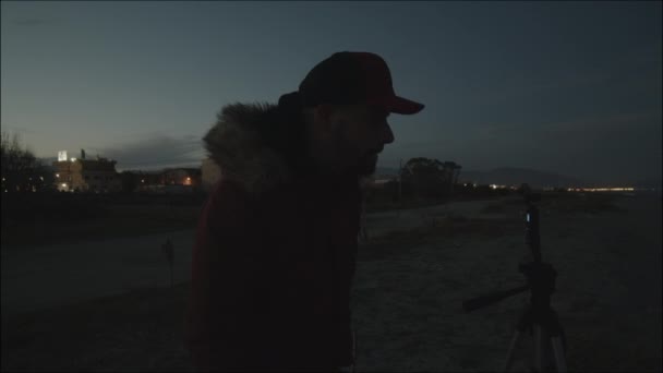 冬服を着た若者が夜に海を撃つ — ストック動画