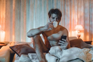 Evde telefonu kötü kullanan genç bir adamın portresi. 