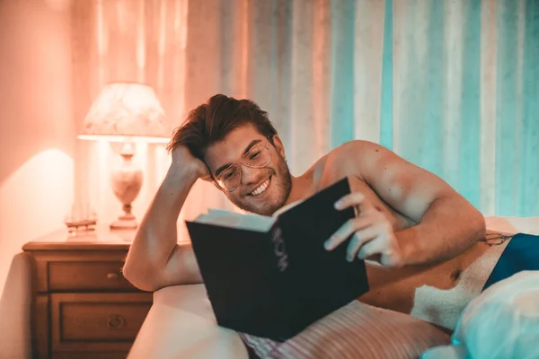 Portrait Young Man Reading Book Bad Home Interior — Stok Foto