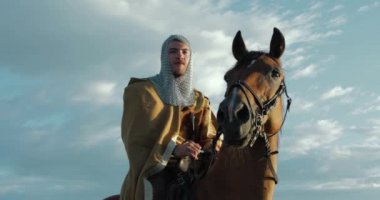 Gündüz vakti okyanus kıyısında ata binen Viking. 