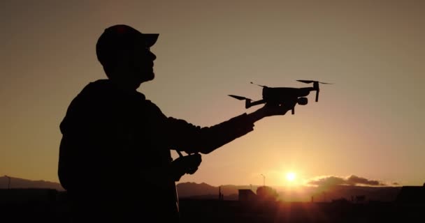 Siluet Manusia Menggunakan Drone Remote Kontrol Luar Ruangan Saat Matahari — Stok Video