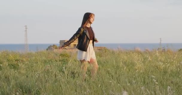 Young Girl White Shorts Black Leather Jacket Walking Summer Field — Stock Video