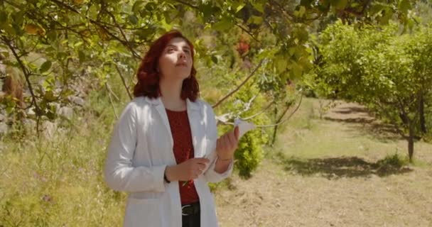 Young Female Agronomist Working Summer Garden Redhead Woman Checking Trees — Stock Video