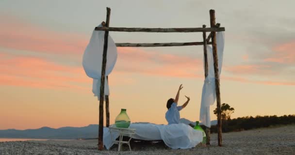 Young Girl Blue Shirt Resting Canopy Bed Ocean Beach Sunrise — Video