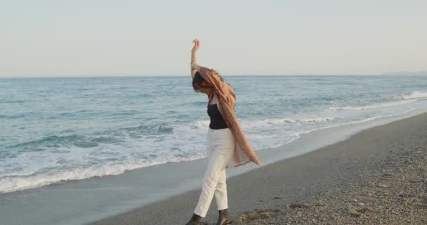 美しいですイタリアの女の子で黒ブーツと白いパンツは夏に海で踊ります — ストック動画