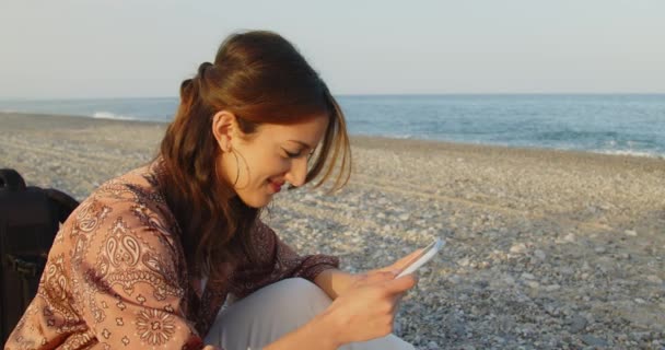 Итальянская Девушка Черных Сапогах Белых Штанах Отдыхающая Море Пользующаяся Смартфоном — стоковое видео