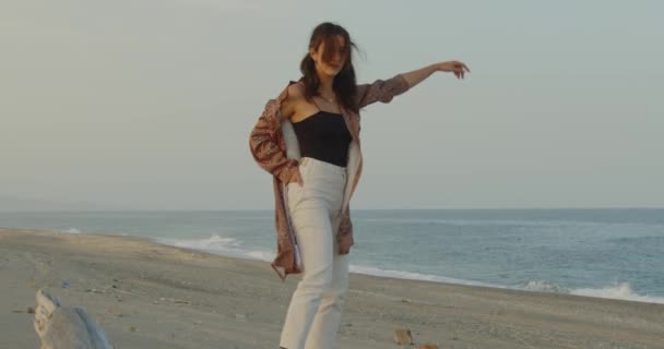 美しいですイタリアの女の子で黒ブーツと白いパンツは夏に海で踊ります — ストック動画