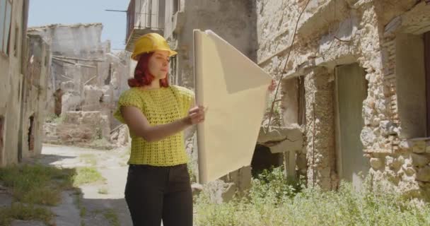 Відеозапис Красивого Італійського Архітектора Жовтому Шоломі Молода Жінка Прокрученими Кресленнями — стокове відео