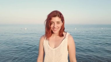 Kumsalda kızıl saçlı şehvetli bir kız.