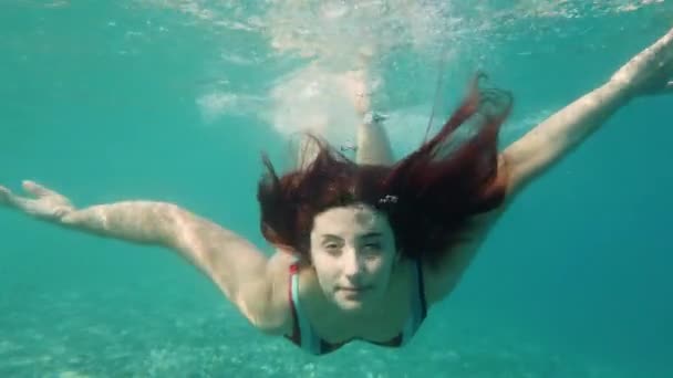 Schöne Frau Schwimmt Unter Der Meeresoberfläche — Stockvideo