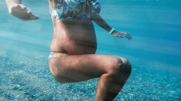 Hamile kadın okyanusta yüzüyor. Doğum öncesi egzersizleri.