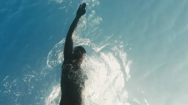 Genç adam denizde yüzüyor. Su altı görüntüsü