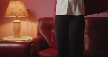 Genç bir kadının portresi. Kırmızı ceketini çıkarıp kanepede oturuyor.