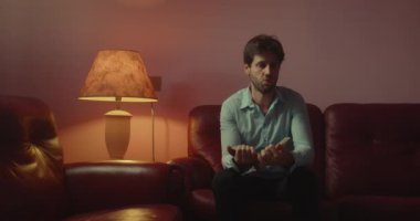 Yakışıklı genç adam evde kanepede otururken kitap okuma