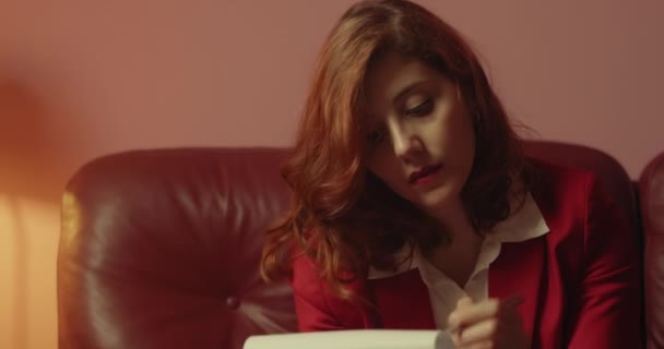 ソファに座ってノートを作る女性の肖像画 — ストック動画