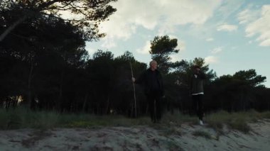 Öğleden sonra, Çam Ormanı 'nın yanında Sahil yolunda yürüyen iki adam..