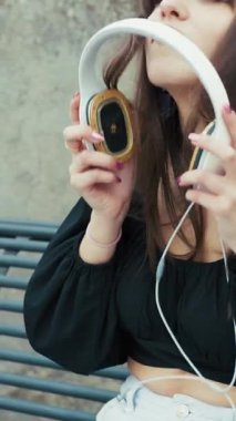 Kadın bankta otururken kulaklığı çıkartıyor.. 