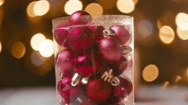 Bir adamın elinde tuttuğu küçük kırmızı Noel süsleri..