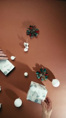 Kahverengi arka planda beyaz hediyeler ve toplarla Noel süsleri..