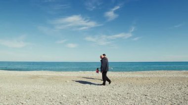 Erkekler güneşli bir günde sahilde yürür.