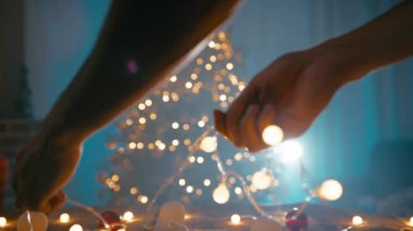 Noel ışıklarını gece ağacın önüne dizen bir çocuğun elleri..