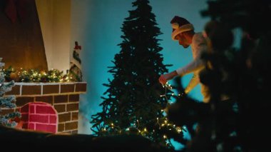 Beyaz LED Işıklarla Dans Ederken Adam Noel Ağacı 'nı süslüyor.