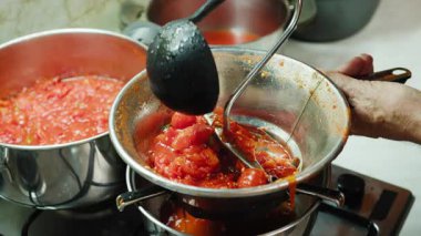 Sicilya 'da geleneksel bir yiyecek olan bir makineyle domates püresi yapmak.