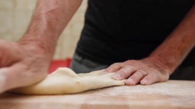 Bir adam kesim tahtasında tipik bir Apulia yemeği olan ev yapımı makarna hazırlıyor..