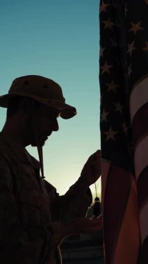 Gün batımında ölen gazileri hatırlayan bir Amerikan askerinin silueti..