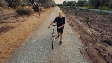 Yaşlı İtalyan adam bisikletiyle yolda yürüyor..
