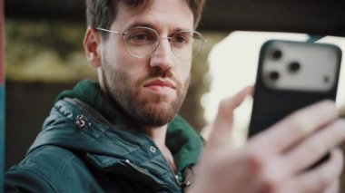 Bir adam akıllı telefonuyla en iyi pozu vermeye çalışır...