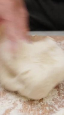 Tahta kesme tahtasındaki tipik İtalyan makarnası için un ve su hamuru.