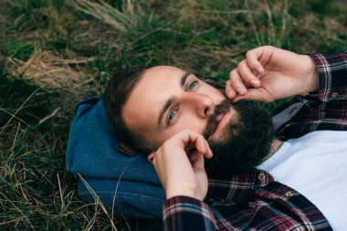 Sakallı adam çim üzerinde yalan