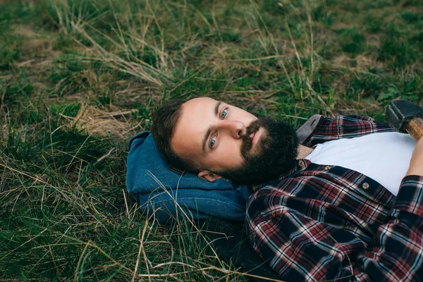 Vousatý muž ležící na trávě — Stock fotografie