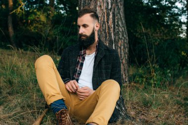 Portre acımasız sakallı ve bıyıklı oduncu hipster çingene adam ormanda balta ile
