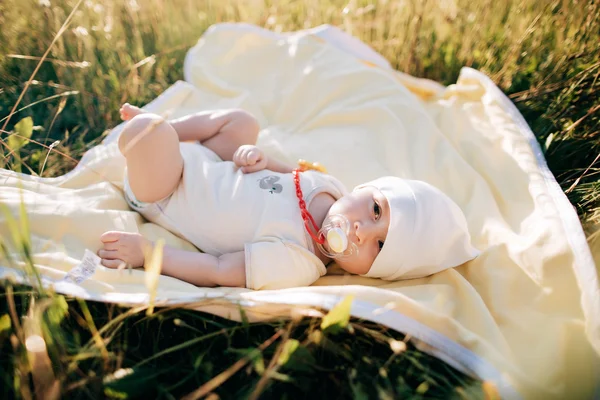 面白い新生児ダミーを夏の日に草に横たわって — ストック写真