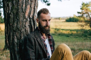 Portre acımasız sakallı ve bıyıklı oduncu hipster çingene adam ormanda balta ile